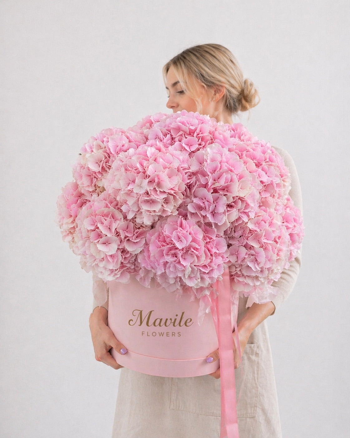 Fresh pink hydrangea floral arrangement near me in decorative pink box held by woman