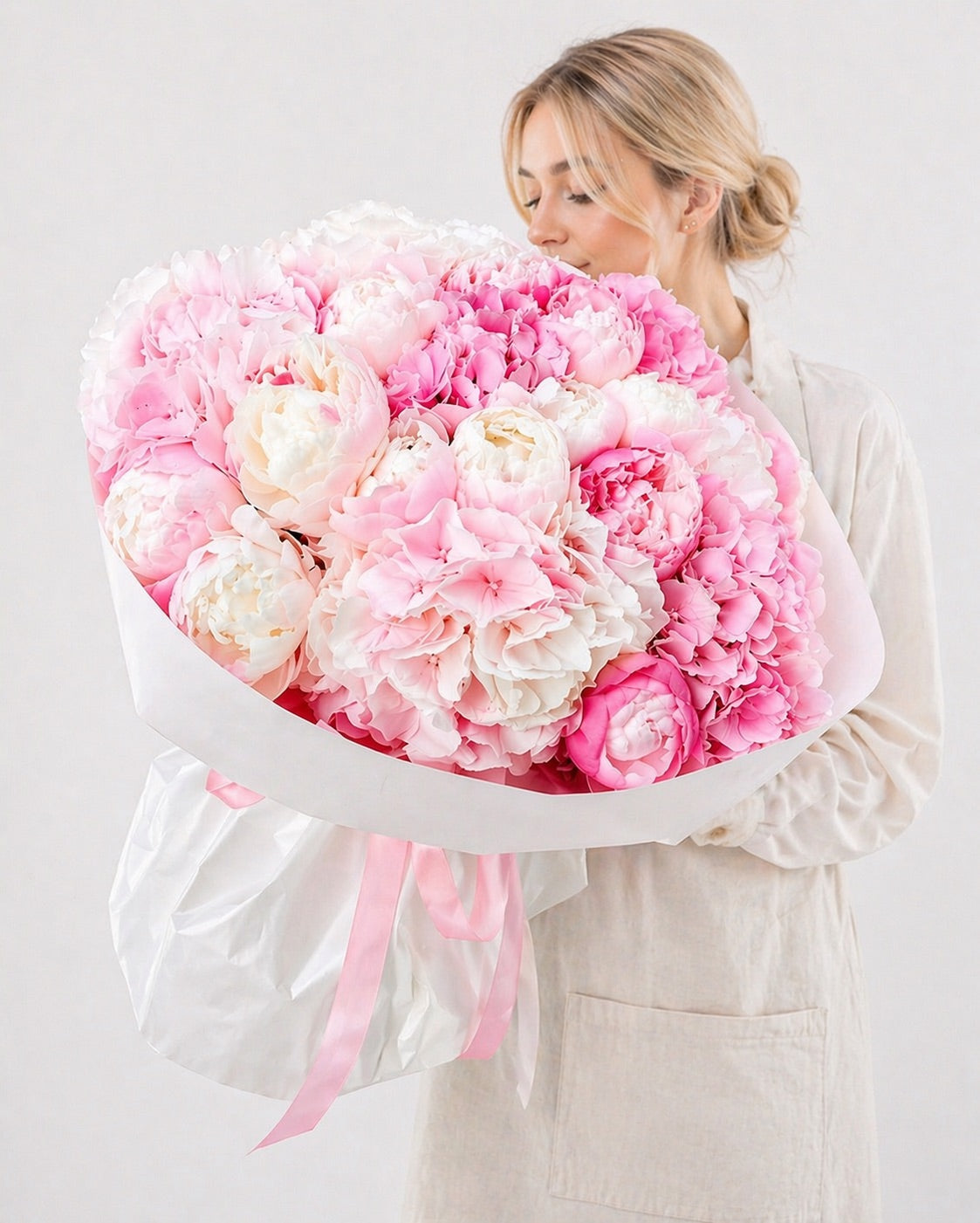 Fresh flower arrangement of pink and white peonies by FSMIA called olive garden held by woman